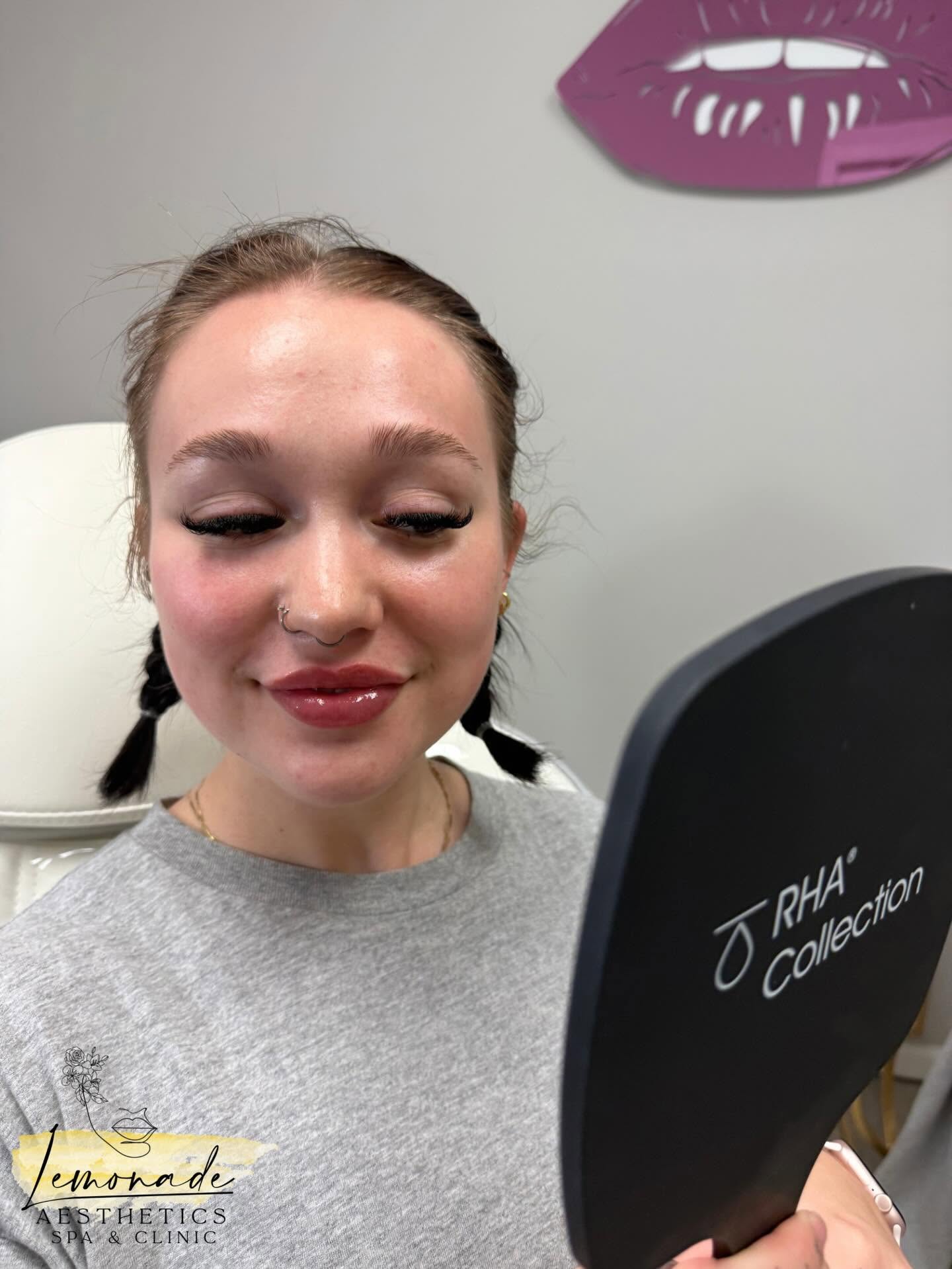 Client looking in a mirror after an appointment at Lemonade Aesthetics